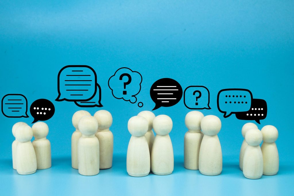 Wooden figures with chat icons representing Mocean Web Portal for Philippines business owners and marketers to send SMS campaigns easily.